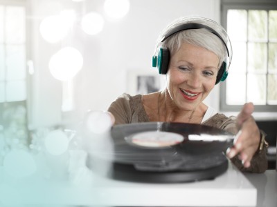 Klassische Rentenversicherung - KlassikClever: Ältere Frau mit Kopfhörer legt Schallplatte auf