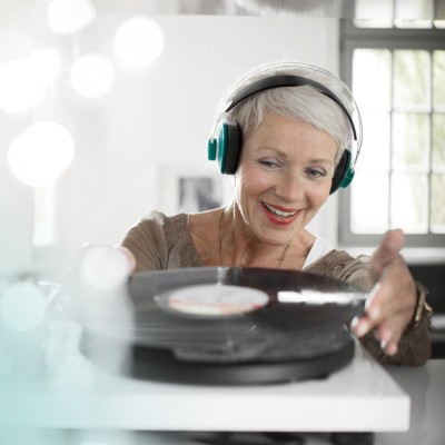 Klassische Rentenversicherung - KlassikClever: Ältere Frau mit Kopfhörer legt Schallplatte auf