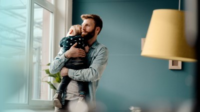 Risikolebensversicherung: Mann hält Baby in Armen