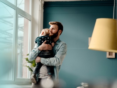 Risikolebensversicherung: Mann hält Baby in Armen