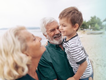 Kindervorsorge: Großeltern mit Enkelkind auf dem Arm