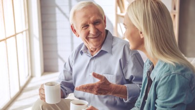 Alter Mann und junge Frau unterhalten sich bei einem Kaffee