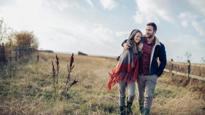 Paar in Umarmung beim Spaziergang auf dem Feld