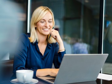 Eine Frau lächelnd am Laptop