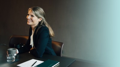 Rechtsanwälte & Steuerberater: Frau im Businessanzug am Konferenztisch