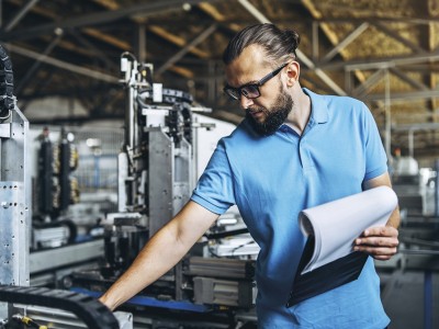 Inhaltsversicherung: Mann an Maschine