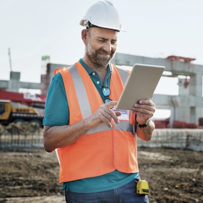 Kautionsversicherung: Bauarbeiter mit Tablet