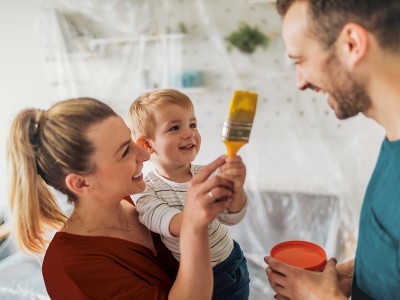 Immobilienrechtsschutz: Junge Familie mit Kind bei Malerarbeiten in der Wohnung