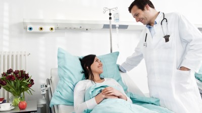 Krankenhauszusatzversicherung: Frau beim Arztgespräch im Einbettzimmer
