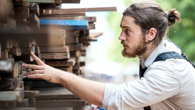 Zimmermann am Holzstapel