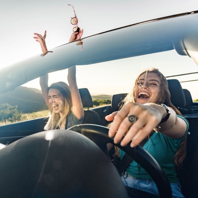 Zusatzfahrer-Versicherung: Zwei Frau im Cabrio entspannt unterwegs